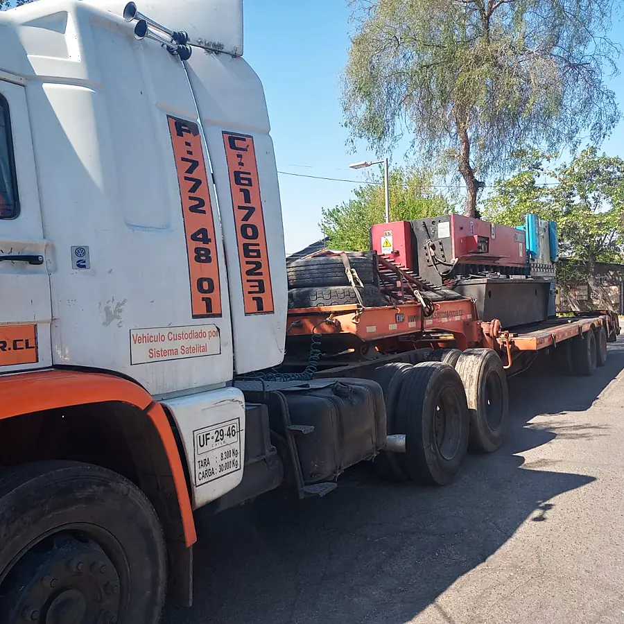 Camión tracto de Grúas Sotomayor enganchado a la cama baja con maquinaria industrial