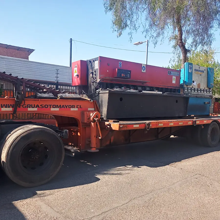 Cama baja transportando una máquina industrial de gran formato por Santiago