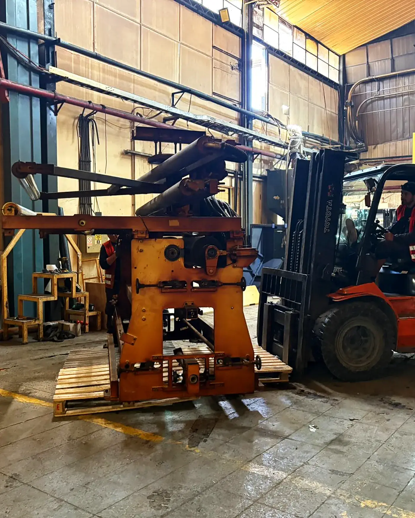Grúa horquilla con manipulador de vidrio operando dentro de una planta